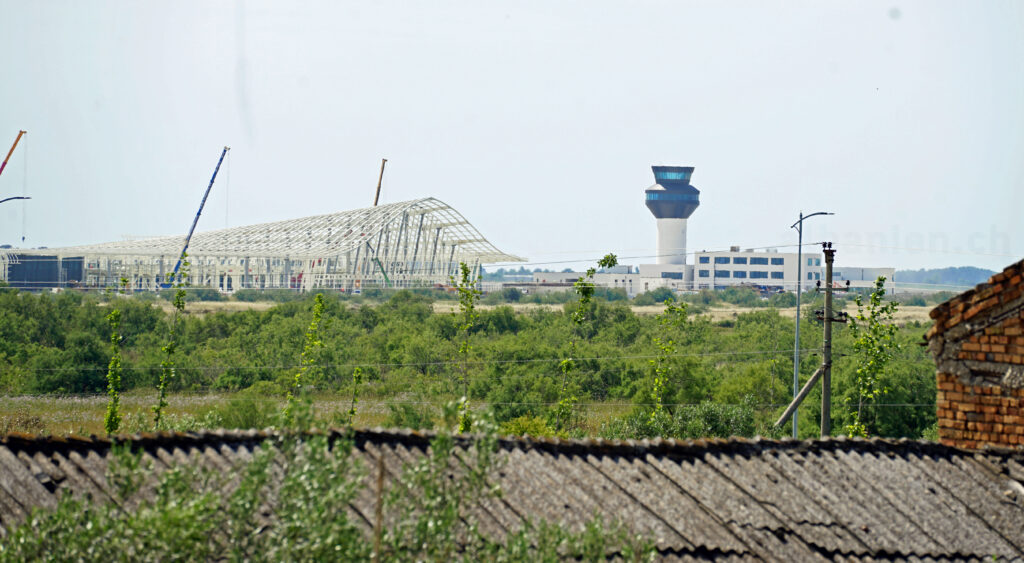 Tower des neuen Flughafens und Stahlgerüst des Terminals während der Bauarbeiten 2025 aus der Distanz